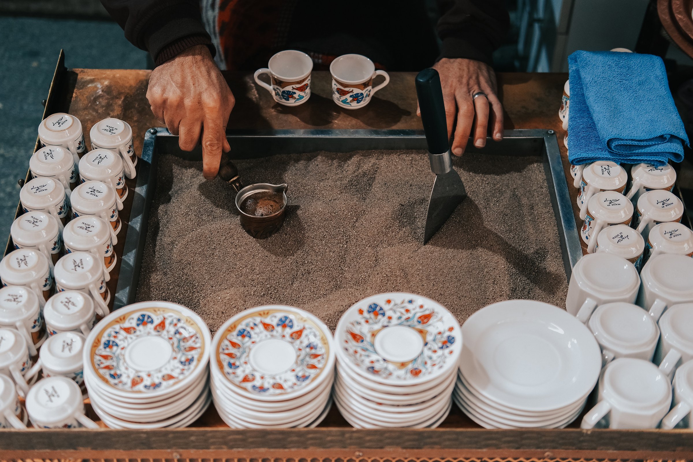 Man Making Traditional Turkish Coffee in Sand